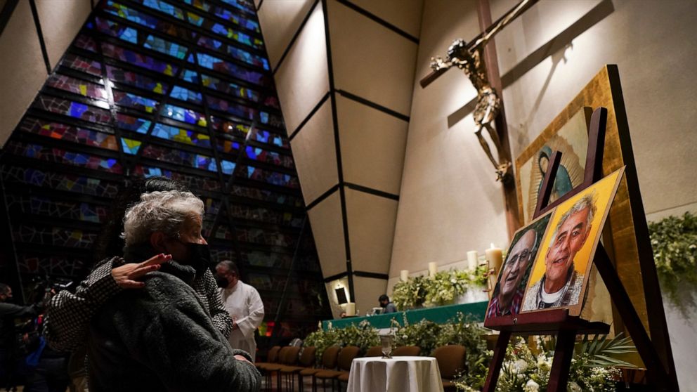 Faithful mourn in front of the photos of Jesuit priests Javier Campos Morales and Joaquin Cesar Mora Salazar during a Mass at a church in Mexico City, Tuesday, June 21, 2022. The two elderly priests were killed inside a church where a man pursued by 