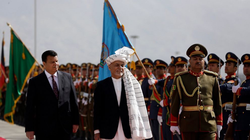 FILE - In this March 6, 2021 file photo, Afghan President Ashraf Ghani, center, inspects an honor guard during the opening ceremony of the new legislative session of the Parliament, in Kabul, Afghanistan. Afghanistan’s embattled president left the co