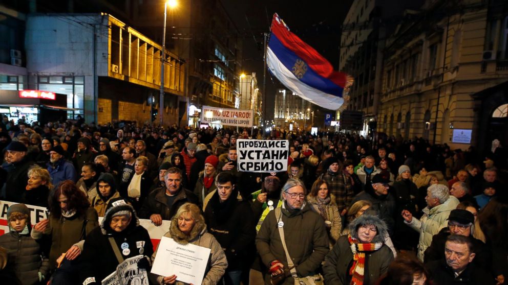 Belgrade Protests For 7th Week Against Serbian Leader Abc News A Man Holds Serbian Flag And Banner That Reads Wake Up Stand