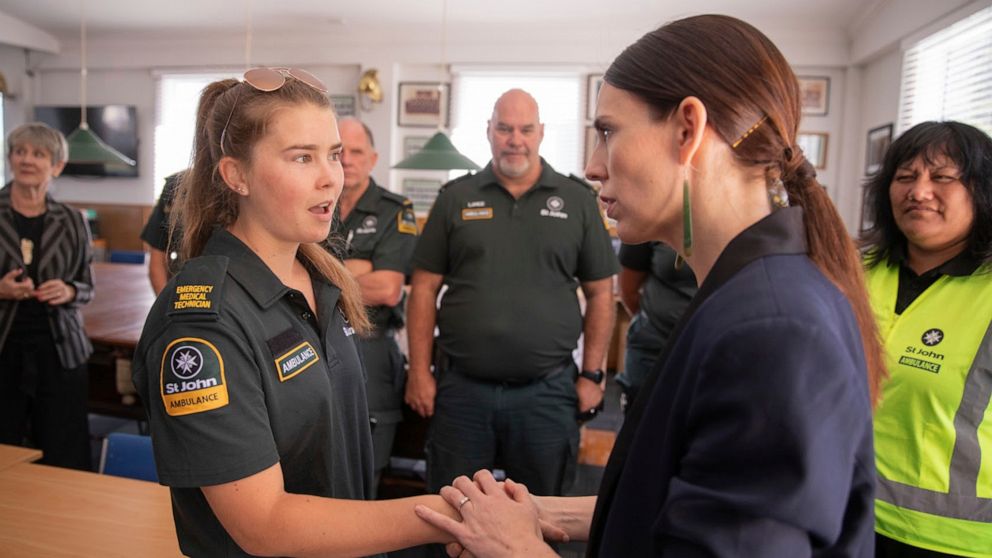 New Zealand's Prime Minister Jacinda Ardern, right, talks with first responders in Whakatane, New Zealand, Tuesday, Dec. 10, 2019. A volcanic island in New Zealand erupted Monday Dec. 9 in a tower of ash and steam while dozens of tourists were explor