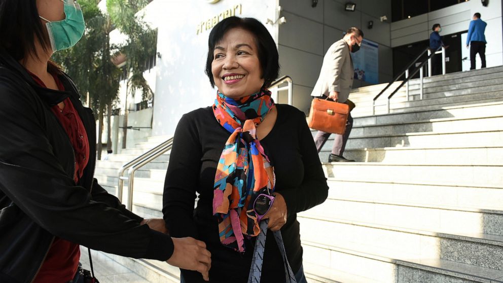 A woman identified only by her first name Anchan, right, talks to her friend as she arrives at the Bangkok Criminal Court in Bangkok, Thailand, Tuesday, Jan. 19, 2021. A court in Thailand on Tuesday sentenced the retired civil servant to a record 43.