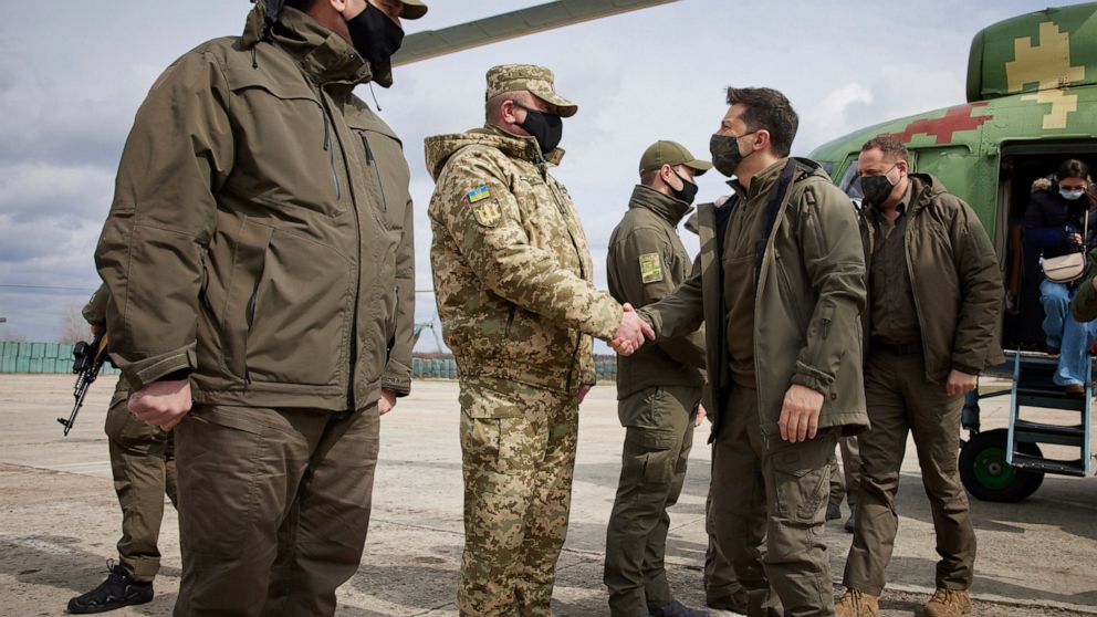 Ukrainian President Volodymyr Zelenskiy shakes hands a soldier as he visits the war-hit Donetsk region, eastern Ukraine, Thursday, April 8, 2021. Ukraine is at the center of a major geopolitical battle in the eastern part of the country with Moscow b