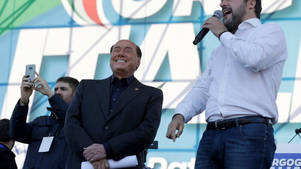 FILE - The League leader Matteo Salvini, right, is flanked by Silvio Berlusconi as he addresses a rally in Rome, on Oct. 19, 2019. The ink had barely dried on the presidential decree putting a premature end to Parliament after Italian Premier Mario D