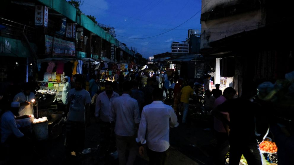 People come out of their homes during a power failure in Dhaka, Bangladesh Tuesday Oct. 4, 2022. A failure in Bangladesh's national power supply grid plunged most of the country into a blackout on Tuesday, officials said.(AP Photo/Mahmud Hossain Opu)
