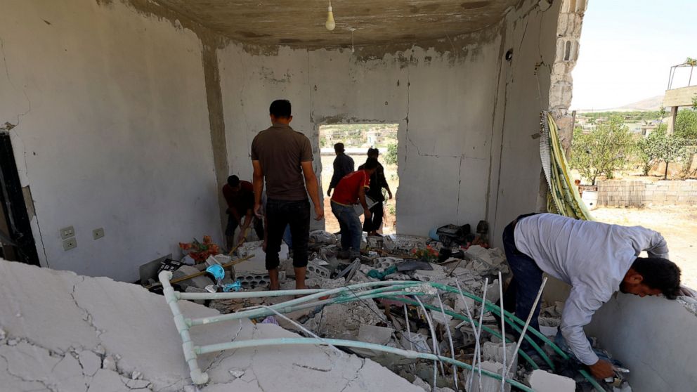 People inspect a damage house after shelling hit the town of Ibleen, a village in southern Idlib province, Syria, Saturday, July 3, 2021. Artillery fire from government-controlled territory Saturday killed at least eight civilians in Syria's last reb