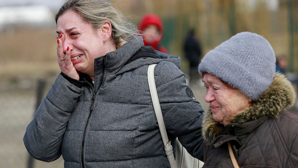 A Ukrainian woman reacts after arriving at the Medyka border crossing, in Poland, Sunday, Feb. 27, 2022. Since Russia launched its offensive on Ukraine, more than 200,000 people have been forced to flee the country to bordering nations like Romania, 