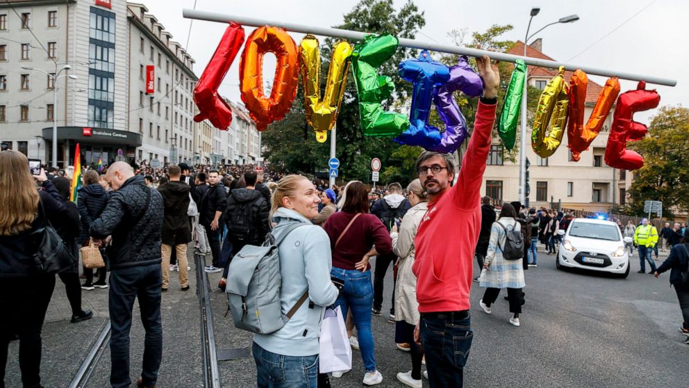 People gather to join a rally of thousands in Bratislava, Slovakia, Friday, Oct. 14, 2022, to honor two gay men who were shot dead in the capital earlier this week and demonstrate support for the LGBTQ community. (Dano Veselsky/TASR via AP)
