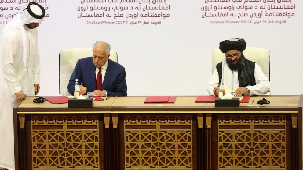 U.S. peace envoy Zalmay Khalilzad, left, and Mullah Abdul Ghani Baradar, the Taliban group's top political leader sign a peace agreement between Taliban and U.S. officials in Doha, Qatar, Saturday, Feb. 29, 2020. The United States is poised to sign a