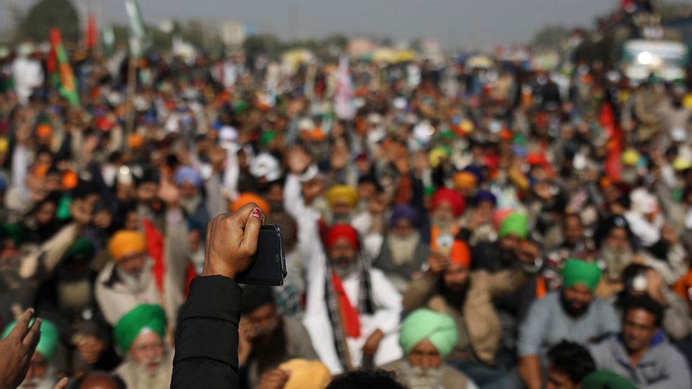 Protesting farmers shout slogans while blocking a major highway, refusing to move ahead unless they're allowed to proceed to their place of choice to protest, at the Delhi-Haryana state border, India, Saturday, Nov. 28, 2020. Thousands of farmers in 