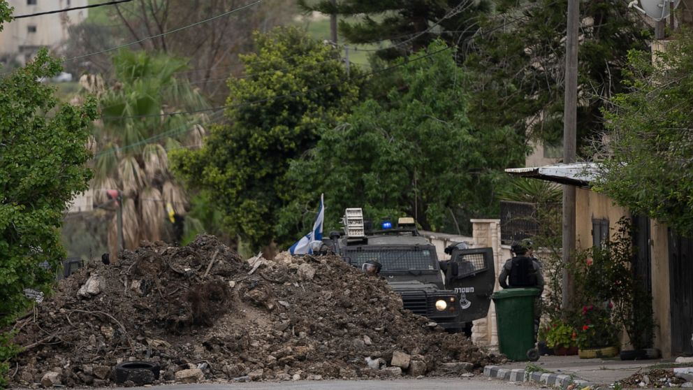 Israeli border police use a mound of earth to close the main entrance of the West Bank village of Burqa, north of Nablus, Tuesday, April 19, 2022. Palestinians protesting against a settlers march toward Homesh, a settlement that was officially disman