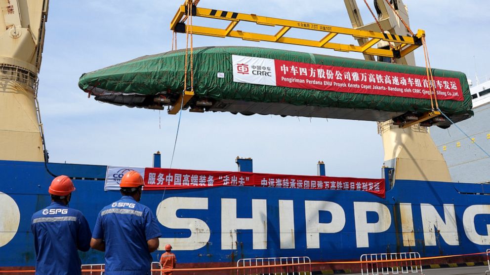 In this photo released by Xinhua News Agency, a high-speed electric passenger train, customized for the Jakarta-Bandung High-Speed Railway (HSR) project, is loaded onto a vessel in Qingdao Port in eastern China's Shandong Province, Aug. 18, 2022. Chi