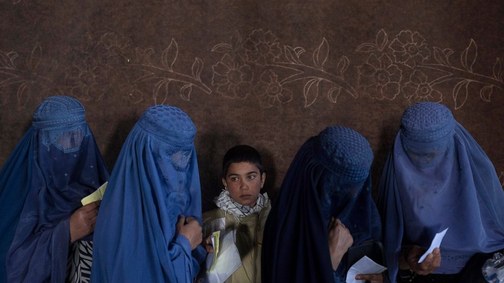 FILE - Afghan women wait to receive cash at a money distribution point organized by the World Food Program, in Kabul, Afghanistan, on Nov. 20, 2021. The lives of Afghan women and girls are being destroyed by the Taliban’s crackdown on their human rig