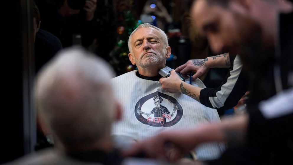 FILE - In this Saturday, Dec. 7, 2019 file photo Labour Party leader Jeremy Corbyn has his beard trimmed in Big Mel's Barbershop, Carmarthen, while on the General Election campaign trail in Wales. (Victoria Jones/PA via AP, File)