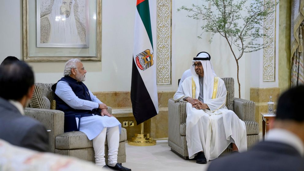 In this photo made available by Ministry of Presidential Affairs, President of the United Arab Emirates Sheikh Mohamed bin Zayed Al Nahyan, right, receives the Prime Minister of India Narendra Modi at the Presidential Airport, in Abu Dhabi, United Ar