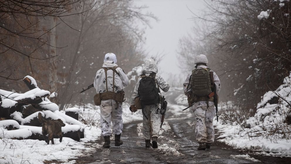 Ukrainian soldiers walks at the line of separation from pro-Russian rebels near Katerinivka, Donetsk region, Ukraine, Tuesday, Dec 7, 2021. Ukrainian authorities on Tuesday charged that Russia is sending tanks and snipers to the line of contact in wa