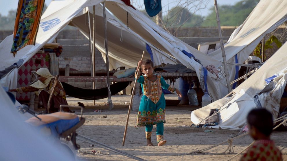 A young girl plays outside her tent at a relief camp, in Jaffarabad, a district in the southwestern Baluchistan province, Pakistan, Thursday, Sept. 29, 2022. Almost 3 million children in Pakistan may miss at least one semester because of flood damage
