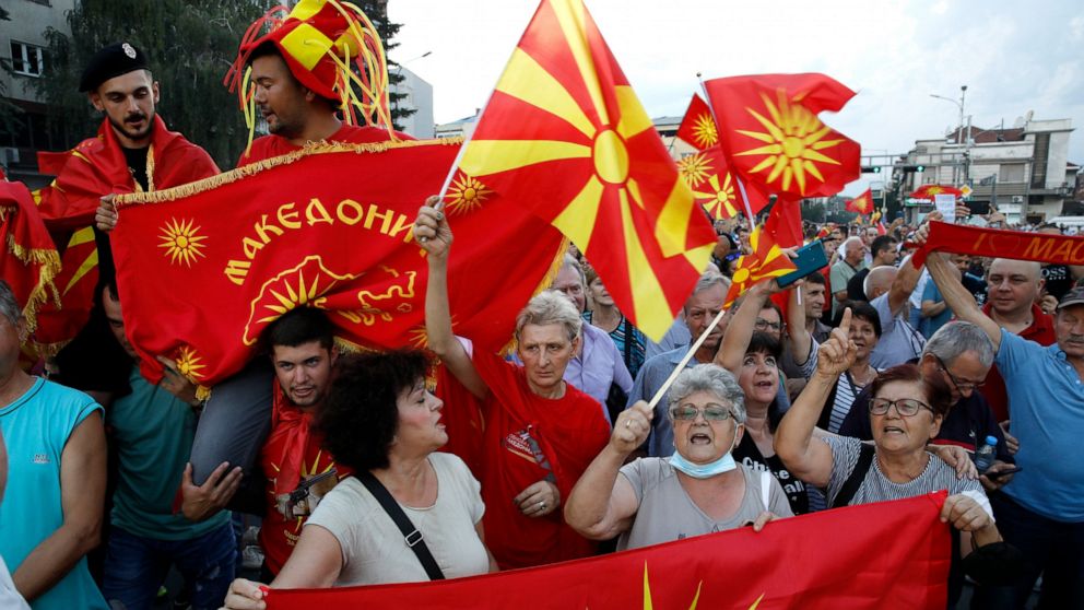 FILE - People wave the old and current national flags during a protest in front of the government building in Skopje, North Macedonia, Saturday, July 2, 2022. Nightly protests in North Macedonia over the past week have left dozens injured. At the hea