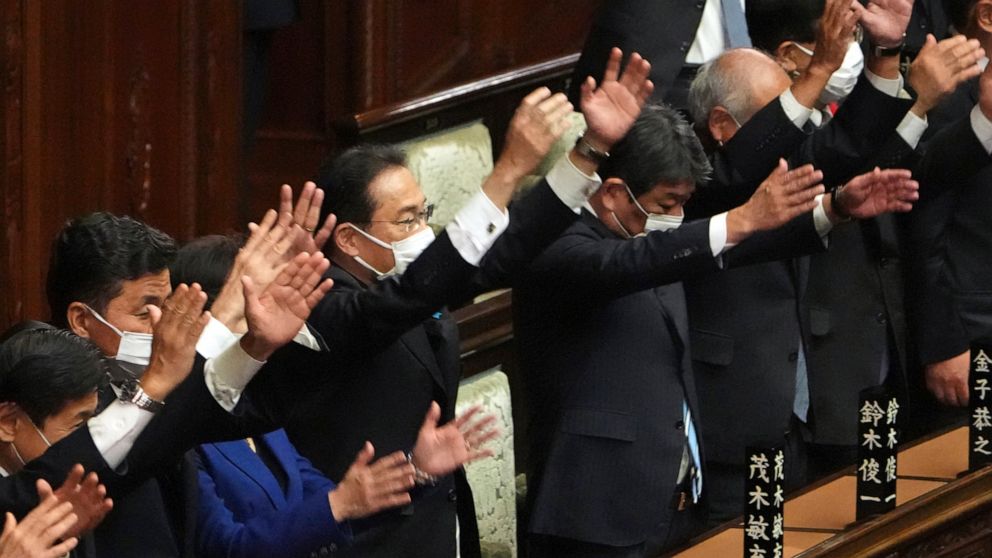 Japanese Prime Minister Fumio Kishida, center, and other lawmakers give three cheers after dissolving the lower house, the more powerful of the two parliamentary chambers, during an extraordinary Diet session at the lower house of parliament Thursday
