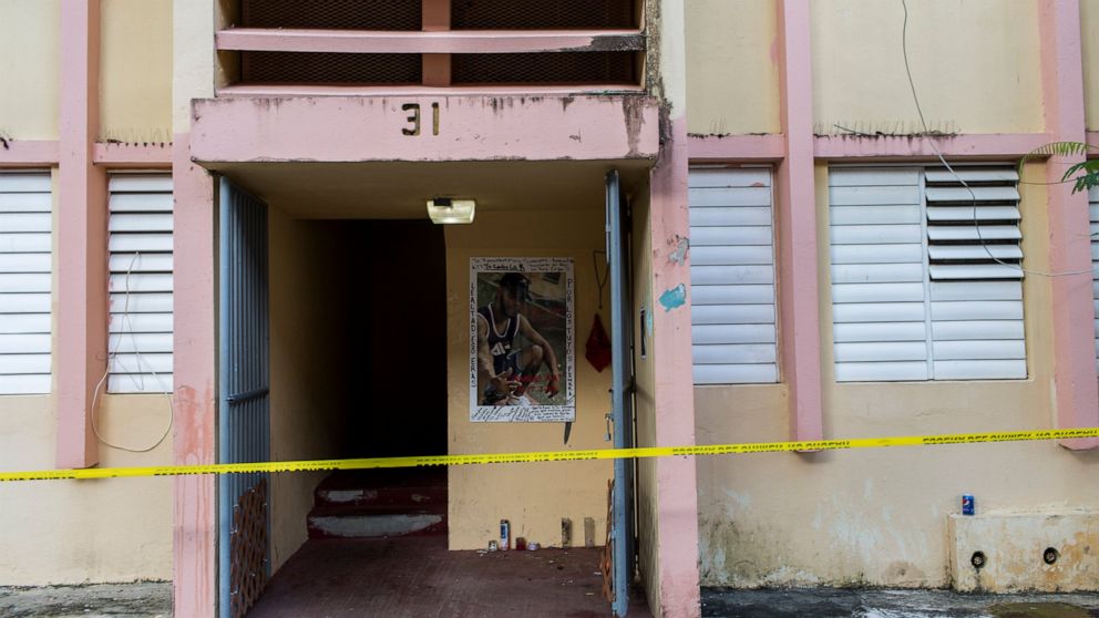 Police tape secures the area of a makeshift altar at the home of a youth that was murdered on Sept. 11, at the scene of a multiple killing in San Juan, Puerto Rico, Tuesday, Oct. 15, 2019. Several people are reported dead following a shooting in the 