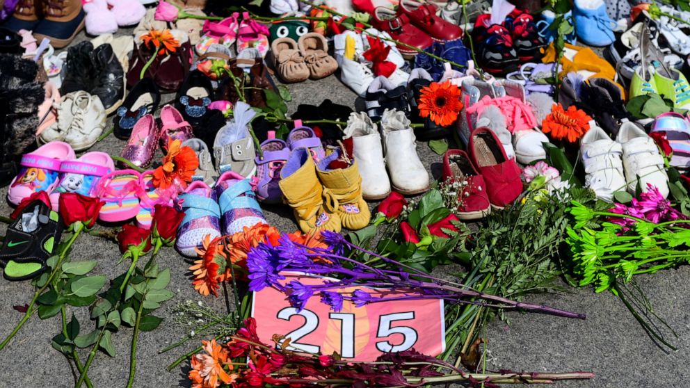 Flowers, children's shoes and other items rest at a memorial at the Eternal flame on Parliament Hill in Ottawa on Tuesday, June 1, 2021, in recognition of discovery of children's remains at the site of a former residential school in Kamloops, British