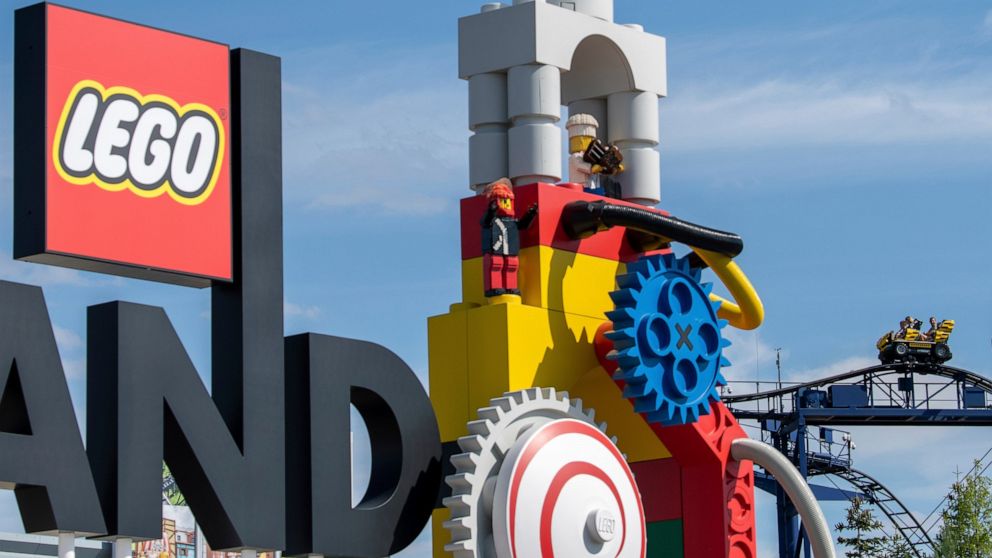 A roller coaster can be seen next to the logo at the entrance to the 'Legoland' amusement park in Guenzburg, southern Germany, Thursday, Aug. 11, 2022. At least 34 people were injured in the accident on a roller coaster at Legoland in Guenzburg, two 