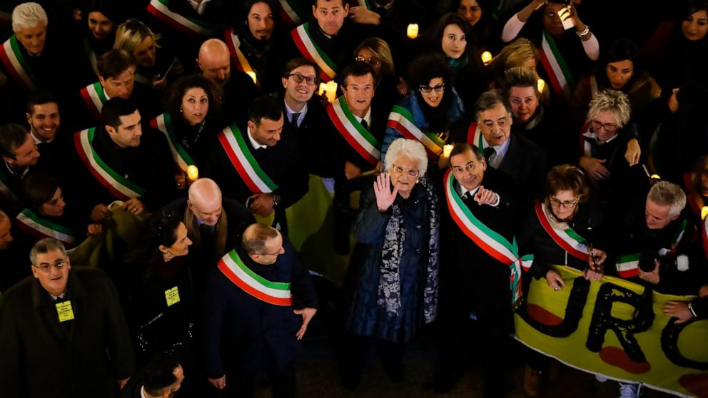 Liliana Segre, an 89-year-old Auschwitz survivor and senator-for-life, center, waves to photographers with Milan's Mayor Giuseppe Sala during an anti-racism demonstration in Milan's Victor Emmanuel II arcade in northern Italy that was joined by mayor