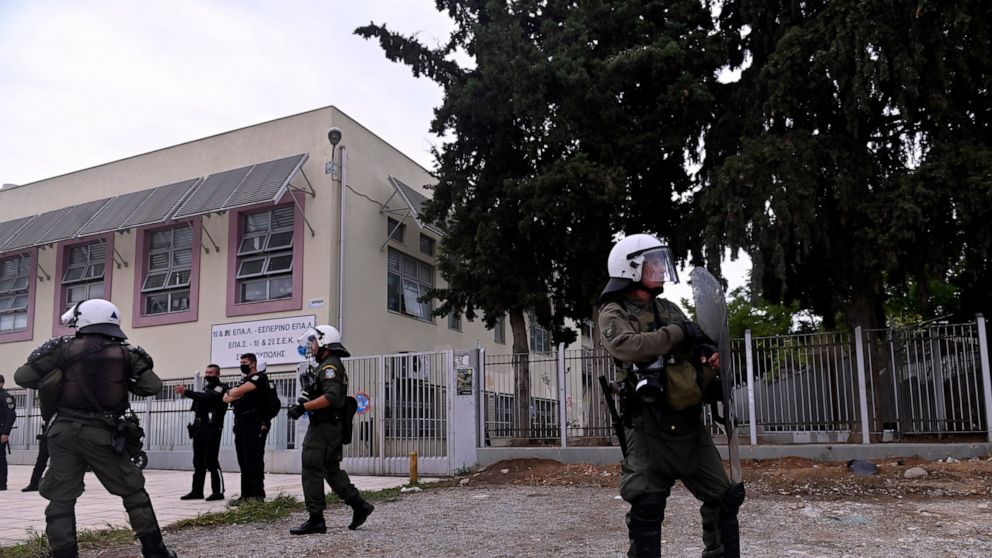 Riot police guard outside a vocational high school after clashes in the northern city of Thessaloniki, Greece, Wednesday, Sept. 29, 2021. Police in the second largest city of the country have arrested five people and detained at least 20 others follo