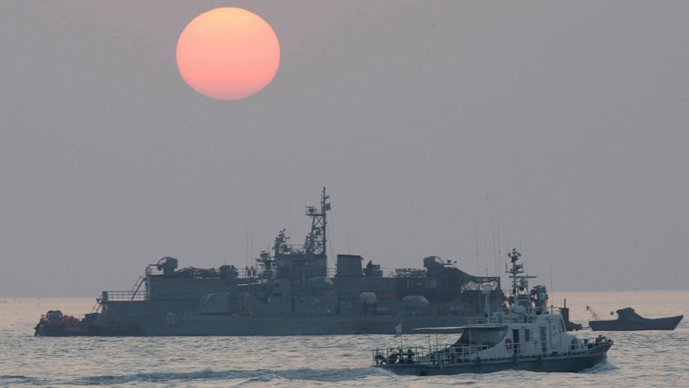 FILE - In this Dec. 22, 2010, file photo, a government ship sails past the South Korean Navy's floating base as the sun rises near Yeonpyeong island, South Korea. A South Korean official who disappeared off a government ship near the disputed sea bou