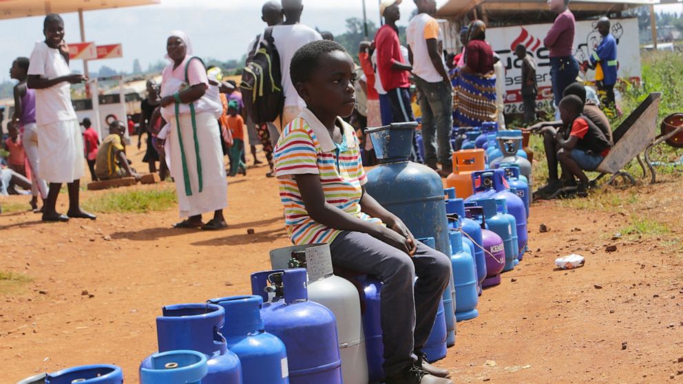 A young boy sits in a queue for cooking gas in Harare, Zimbabwe, Sunday, March, 29, 2020. Zimbabwean President Emmerson Mnangagwa announced a nationwide lockdown for 21 days, starting March 30, in an effort to stop the spread of the COVID-19 pandemic