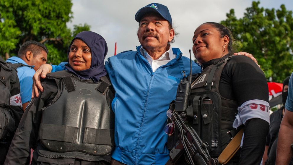 FILE - Nicaraguan police have their picture taken with President Daniel Ortega, in Masaya, Nicaragua, Friday, July 13, 2018. The government of the United States announced on Monday, June 13, 2022, that is restricting visas to members of the governmen