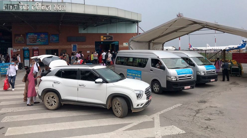 People walk outside the Tribhuvan International Airport in Kathmandu, Nepal, Sunday, May 29, 2022. A small airplane with 22 people on board flying on a popular tourist route was missing in Nepal’s mountains on Sunday, an official said. The Tara Airli
