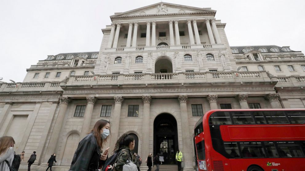 FILE - In this Wednesday, March 11, 2020 file photo, pedestrians wearing face masks pass the Bank of England in London. The Bank of England has kept its main interest rate at the record low of 0.1%. In a statement Thursday, June 24, 2021 accompanying