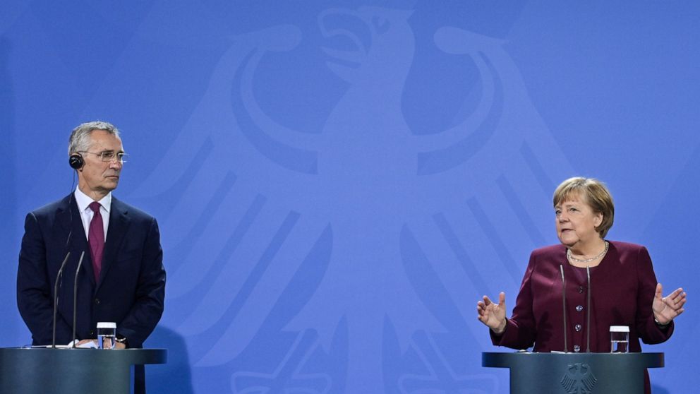 German Chancellor Angela Merkel, right, and NATO Secretary General Jens Stoltenberg give a press statement before talks in Berlin, Germany, on Friday, Nov. 19, 2021. (John MacDougall/Pool Photo via AP)