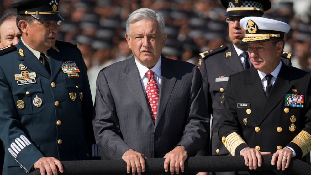 FILE - Mexican President Andres Manuel Lopez Obrador, flanked by Defense Secretary Gen. Luis Crescencio Sandoval, left, and Marine Secretary Jose Rafael Ojeda, surveys National Guard troops as the new force is presented at a ceremony, in Mexico City,