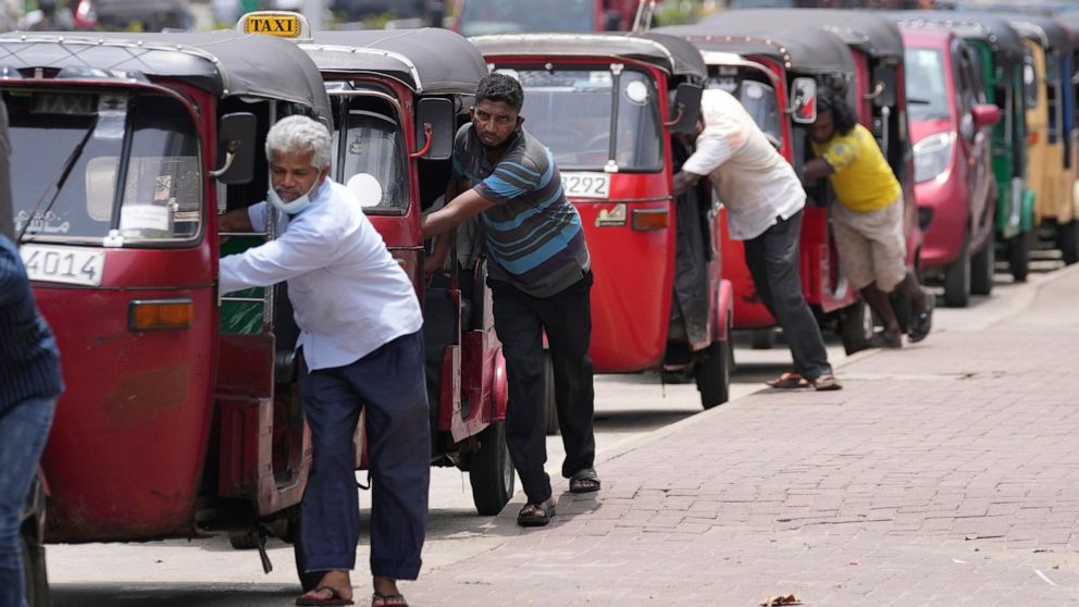 FILE- Sri Lankan auto rickshaw drivers queue up to buy petrol near a fuel station in Colombo, Sri Lanka, April 13, 2022. Sri Lankans are facing a severe economic crisis that has ravaged household budgets amid high inflation. Staple foods are in short