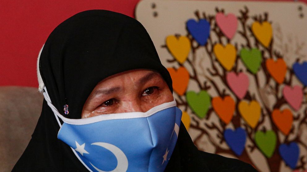 Bumeryem Rozi, 55, an ethnic Uyghur who fled from China to Turkey, cries as she talks to The Associated Press, at her home, in Istanbul, Tuesday, June 1, 2021. Rozi, a mother of four, is one of three Uyghurs who described forced abortions and torture