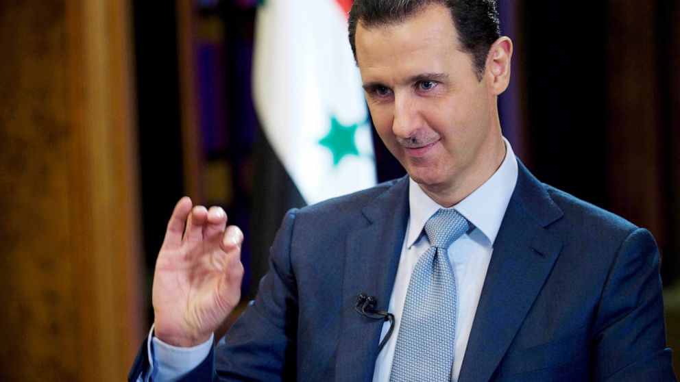 FILE - In this Feb. 10, 2015, file photo released by the Syrian official news agency SANA, Syrian President Bashar Assad gestures during an interview in Damascus, Syria. Assad says members of the Islamic State group held in the country will stand tri