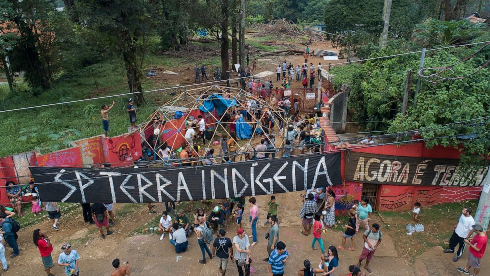 Guarani Mbya indigenous people gather outside a property they have been occupying in an attempt to stop real estate developer Tenda from constructing apartment buildings next to their community's land in Sao Paulo, Brazil, Tuesday, March 10, 2020. Af