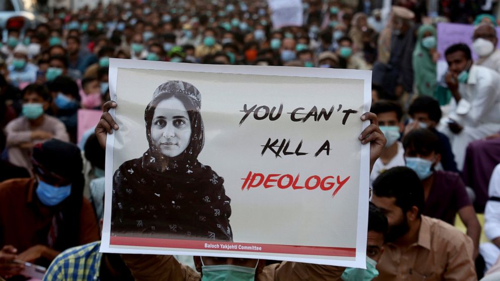 FILE - In this Dec. 24, 2020, file photo, supporters of Baloch political activist Karima Baloch hold here portrait during a demonstration to condemn her killing, in Karachi, Pakistan. Baloch, who died in exile in Canada last month, was brought home a