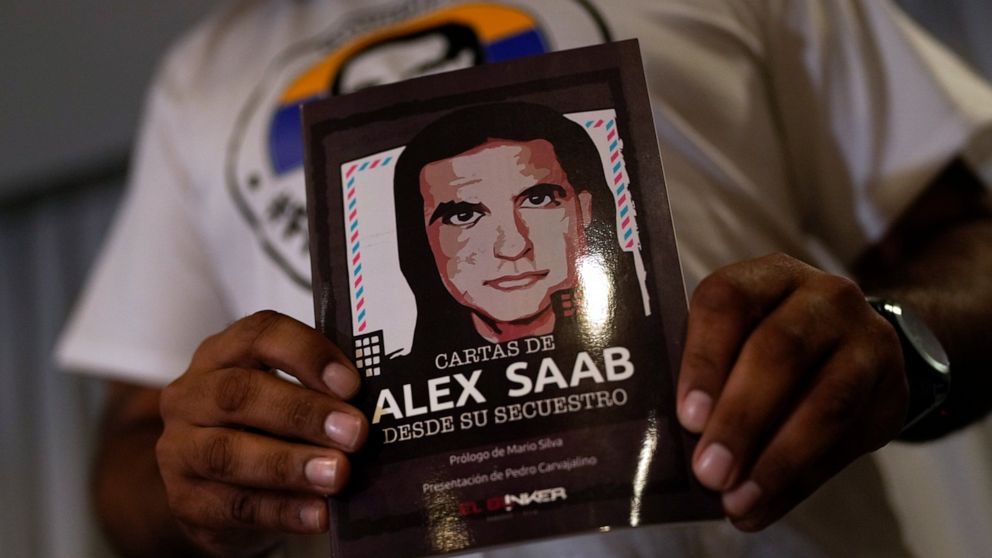 FILE - A member of the Free Alex Saab movement holds an image of Alex Saab during a press conference in Caracas, Venezuela, Aug. 15, 2022. The close ally of Venezuela's President Nicolas Maduro was extradited to the U.S. from Cabo Verde in June 2020,