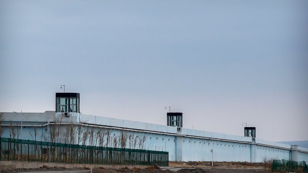 People stand in a guard tower on the perimeter wall of the Urumqi No. 3 Detention Center in Dabancheng in western China's Xinjiang Uyghur Autonomous Region on April 23, 2021. China's largest detention center is twice the size of Vatican City and has 
