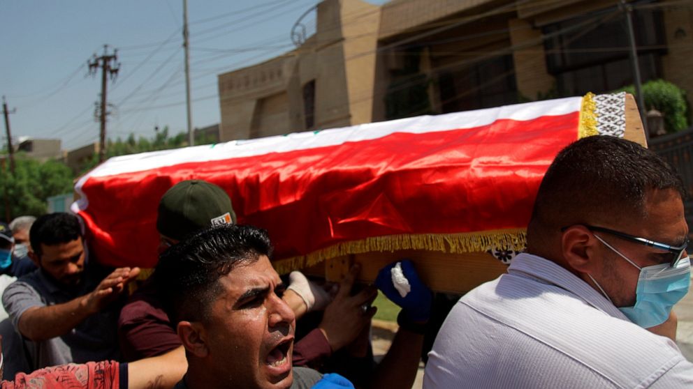 Mourners carry the flag-draped coffin of Hisham al-Hashimi during his funeral, in the Zeyouneh area of Baghdad, Iraq, Tuesday, July, 7, 2020. Al-Hashimi, an Iraqi analyst who was a leading expert on the Islamic State and other armed groups, was shot 