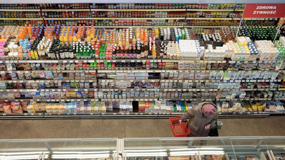 A woman does a shopping in a supermarket in Warsaw, Poland, Friday, Dec. 9, 2022. Prices are surging in Poland, making it among the European Union nations with one of the highest inflation rates. (AP Photo/Michal Dyjuk)