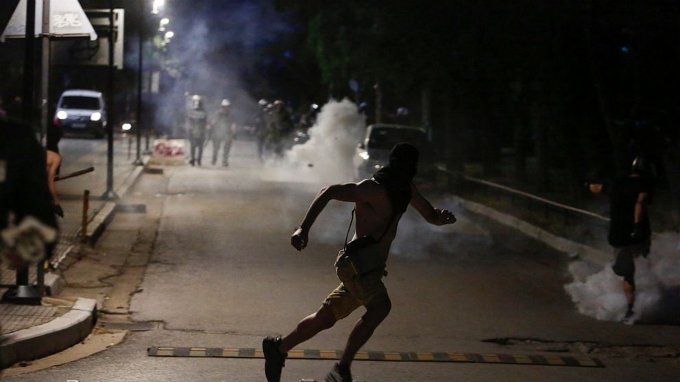 A protester runs during a protest at the University of Thessaloniki in northern Greece, Thursday, May 26, 2022. Earlier Thursday, the protesters faced off with police inside the city's main university campus, where unrest has been bubbling for weeks 