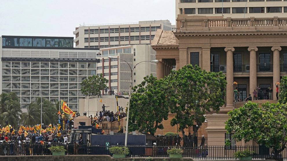 Protesters carrying Sri Lankan flags gather outside the presidents office in Colombo, Sri Lanka, Saturday, July 9, 2022. Sri Lankan protesters stormed President Gotabaya Rajapaksa's residence and nearby office on Saturday as tens of thousands of peop
