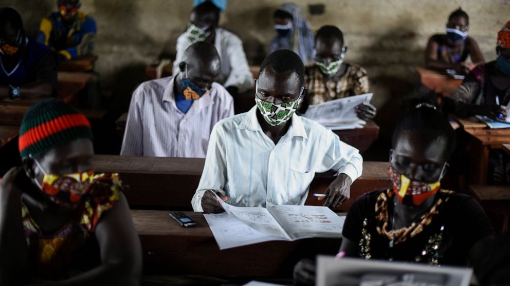A trainee reads a handbook on coronavirus prevention, at a training session for community health workers conducted by the national NGO "Health Link" in Gumbo, on the outskirts of Juba, South Sudan, Tuesday, Aug. 18, 2020. The coronavirus is exposing 