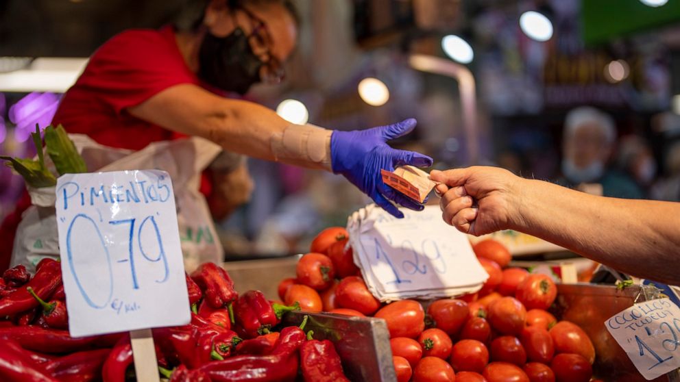 FILE - A customer pays for vegetables at the Maravillas market in Madrid, on May 12, 2022. Inflation figures for Europe will be released Friday, July 1, 2022, as Russia's war in Ukraine has worsened the worldwide surge in consumer prices. For months,