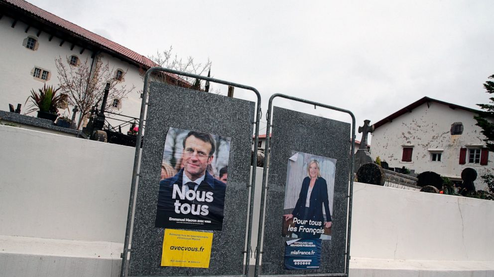 Presidential campaign posters of French President and centrist candidate for reelection Emmanuel Macron and French far-right presidential candidate Marine Le Pen in Arbonne, southwestern France, Tuesday, April 19, 2022. French President Emmanuel Macr
