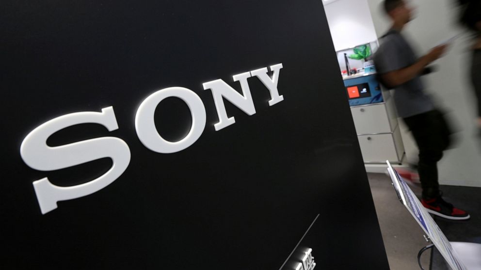 FILE - Visitors walk past a logo of Sony at Sony Building in Tokyo, July 31, 2014. Sony’s quarterly profit through September rose 24% on healthy demand for its music and movies, prompting the Japanese entertainment and electronics company to raise it