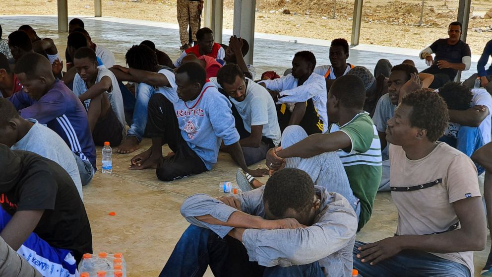 Rescued migrants rest near the city of Khoms, around 120 kilometers (75 miles) east of Tripoli, Libya., Tuesday, Aug. 27, 2019. At least 65 migrants, mostly from Sudan, were rescued, said a spokesman for Libya's coast guard, with a search halted for 